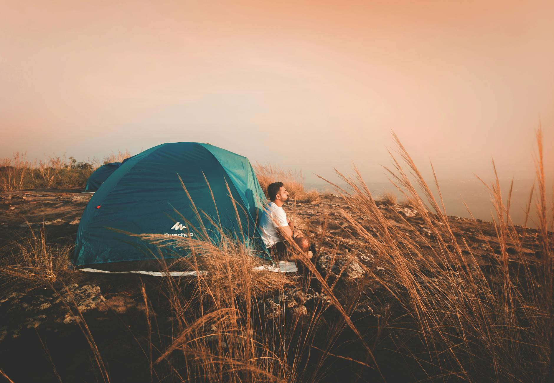 photo of a man sitting outside the tent