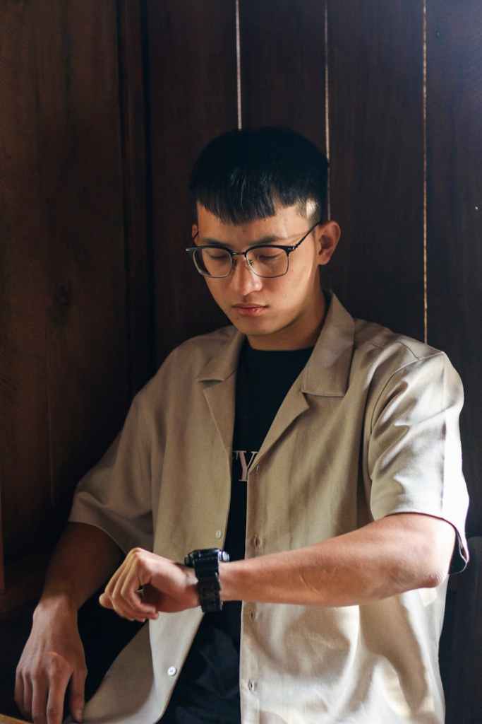 man in shirt checking time on wristwatch