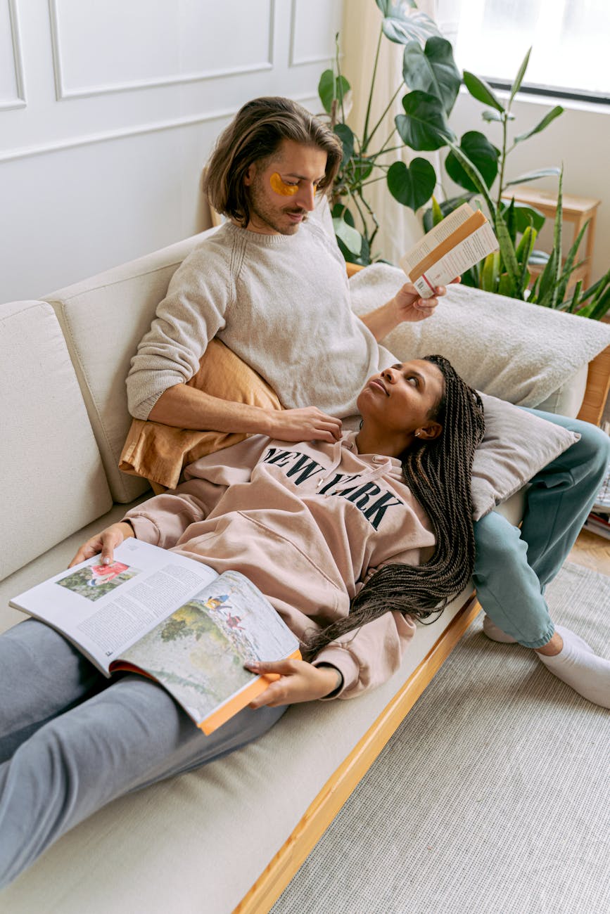 a couple lying on the sofa and reading books