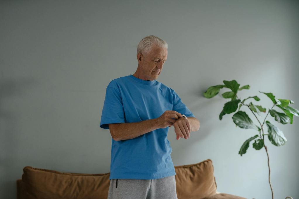 an elderly man in blue shirt looking at his watch