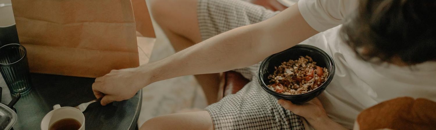 person in white long sleeve shirt holding white ceramic mug