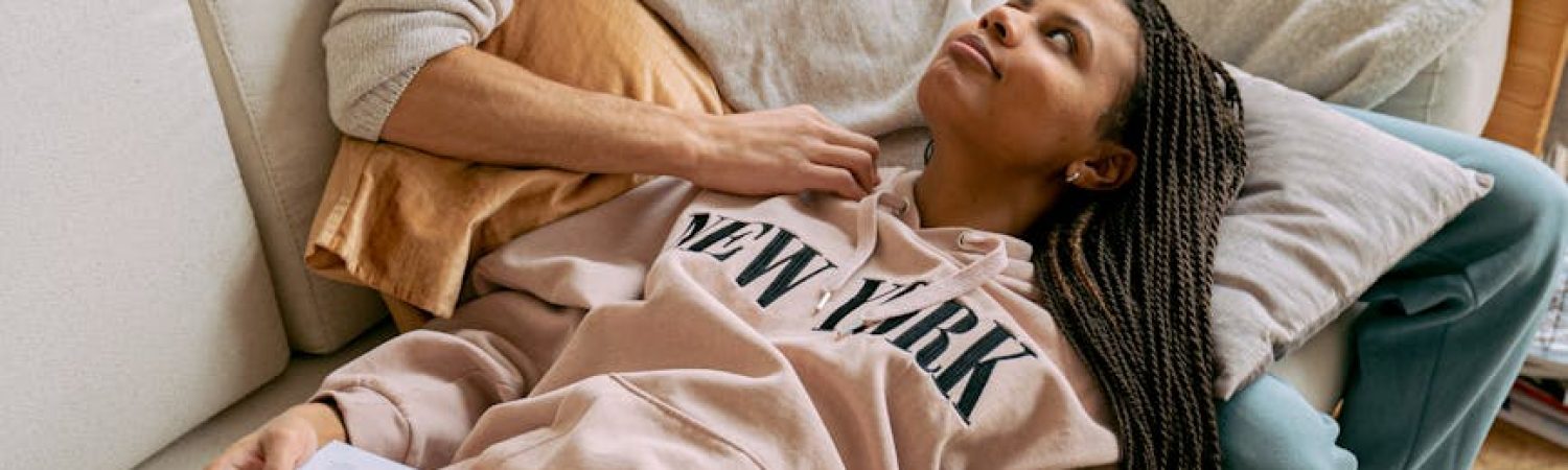 a couple lying on the sofa and reading books